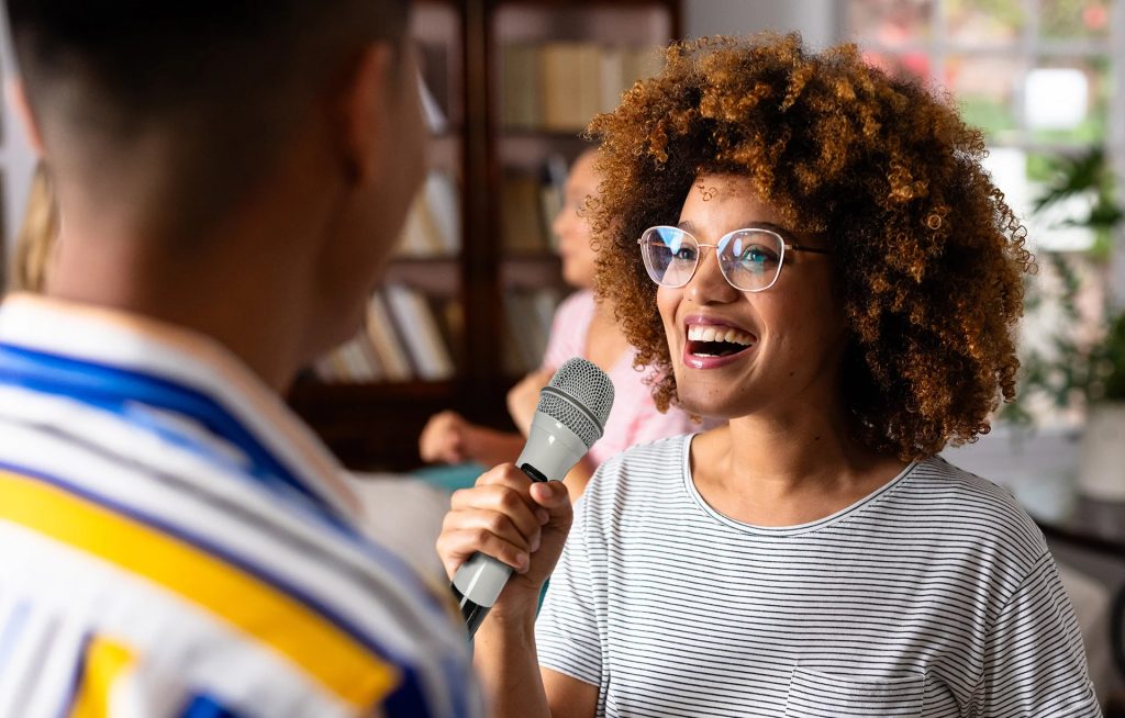 Lady singing karaoke as part of a hen do 